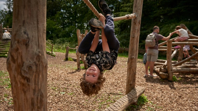 A child playing on a rope at the 'Kestrel Corner' play area at Polesden Lacey, Surrey
